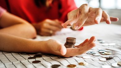 Two people counting change to create more money and happiness