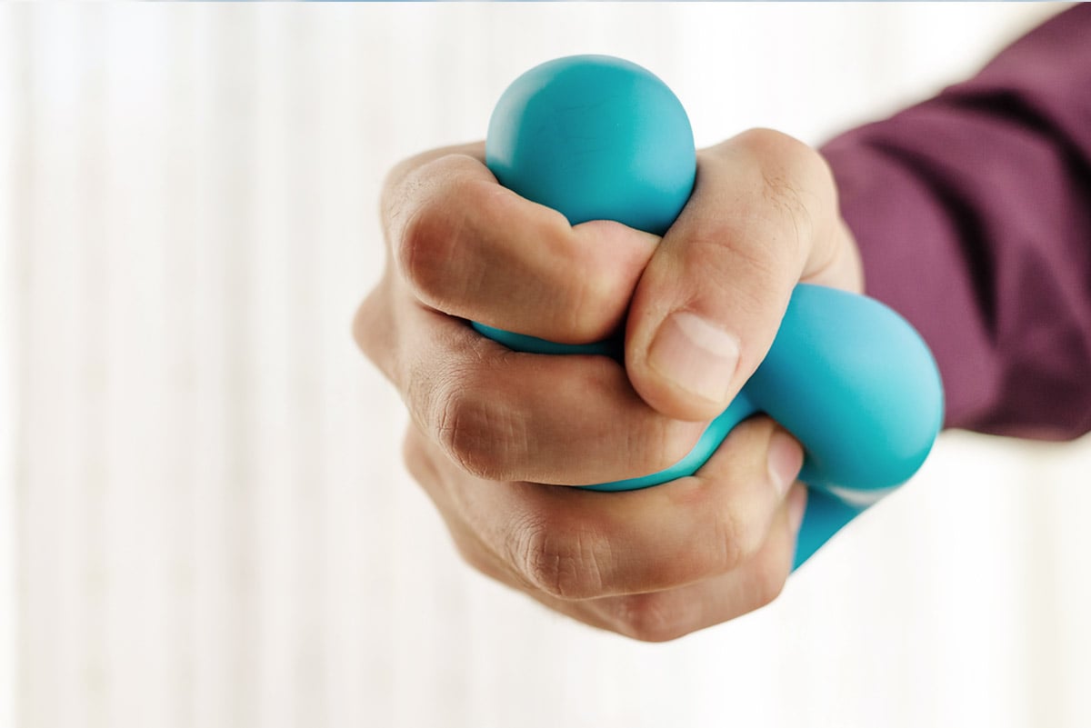 Man's hand squeezing a stress ball