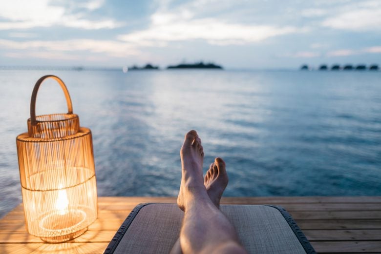 view of a person relaxing on a dock by the ocean