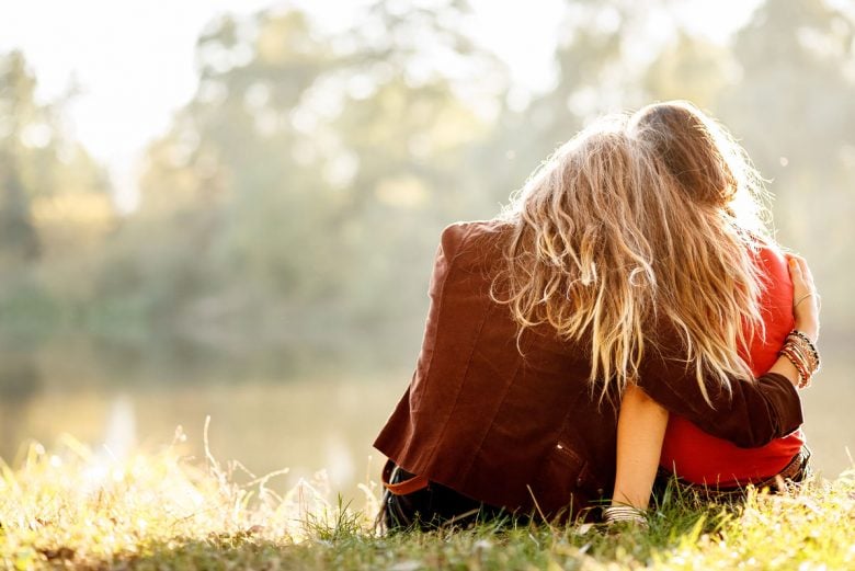 What it means to forgive - two women sitting on grass together