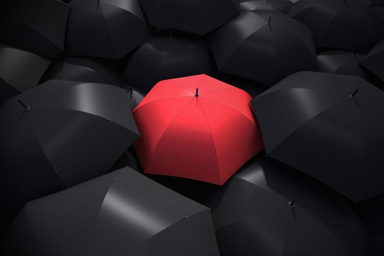 Red umbrella among black umbrellas - protect your energy from toxic people