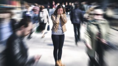 Woman standing in crowded busy city