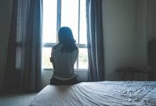 Woman looking out the window, frustrated her healing isn't working anymore