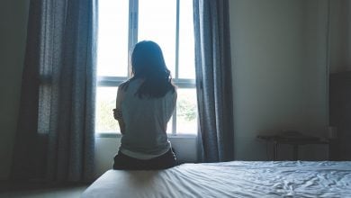 Woman looking out the window, frustrated her healing isn't working anymore