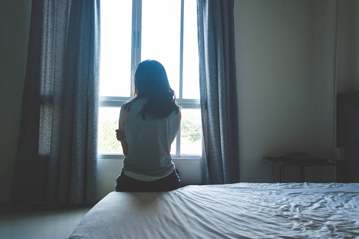 Woman looking out the window, frustrated her healing isn't working anymore