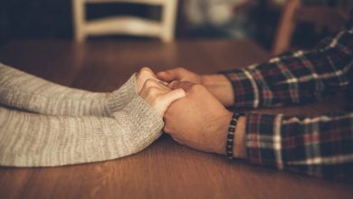 Couple holding hands across the table, creating connection