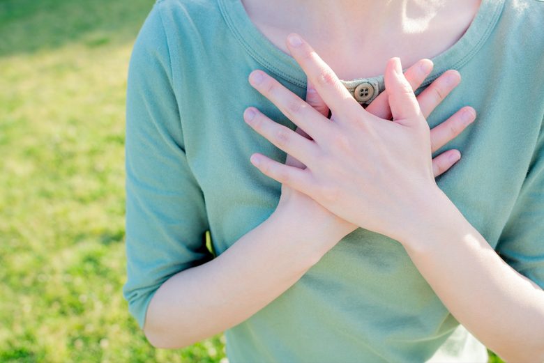 Does Energy Healing Really Work? Woman with hands over heart