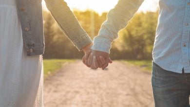 Woman and man holding hands as the walk down a path