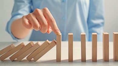 Woman stopping dominoes from falling further