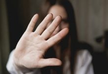 Woman holding hand up in front of her face