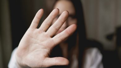 Woman holding hand up in front of her face