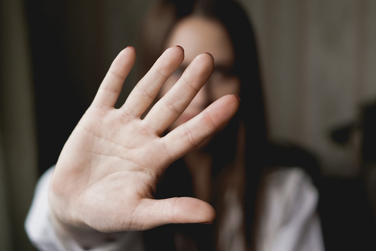 Woman holding hand up in front of her face