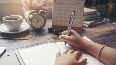 Woman writing in journal planning for 2020