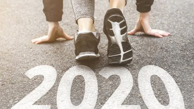 Person ready to start running by pavement with 2020 painted on