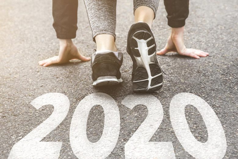 Person ready to start running by pavement with 2020 painted on