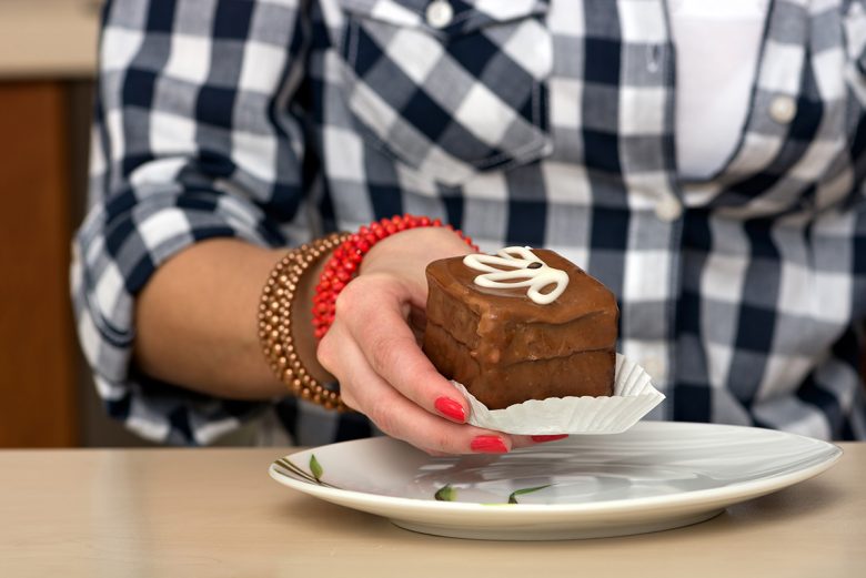 Woman holding piece of chocolate cake