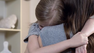 Child crying on mother's shoulder