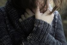 Woman sad with arms crossed by face
