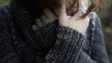Woman sad with arms crossed by face