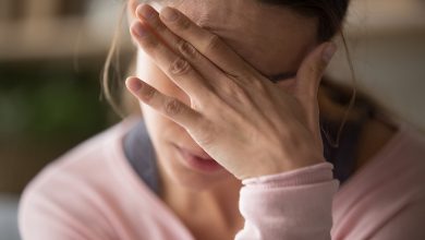 Stressed woman covering her face with one hand