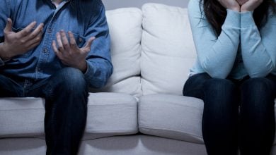 Man and woman sitting on a couch arguing
