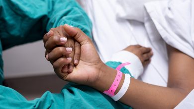 Patient in hospital bed holding someone's hand