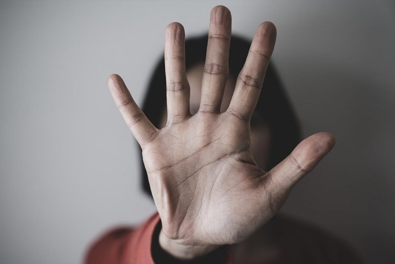 Woman holding hand in front of face - resistance to doing healing work