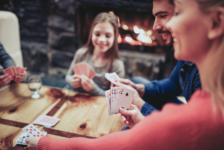 Family gathered around table playing cards - hidden blessings of 2020