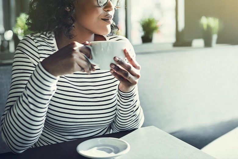 Woman sitting in coffee shop looking out the window