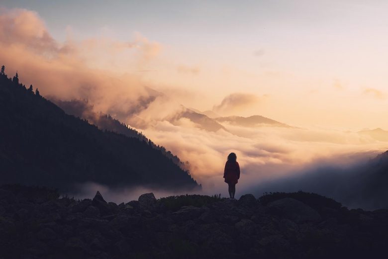 How to recover and fully heal after divorce - woman standing in nature among mountains