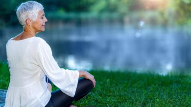 Older woman sitting by lake