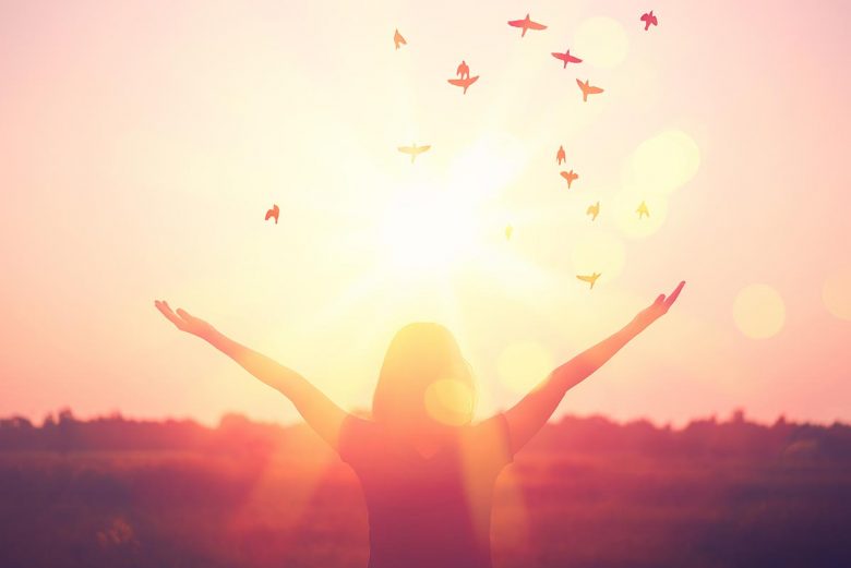 Woman standing in front of the sunset