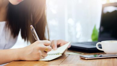 Asian woman journaling with the Healing Center
